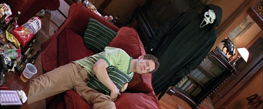 Randy crie “behind you” en regardant Halloween tandis que Ghostface est derrière lui.